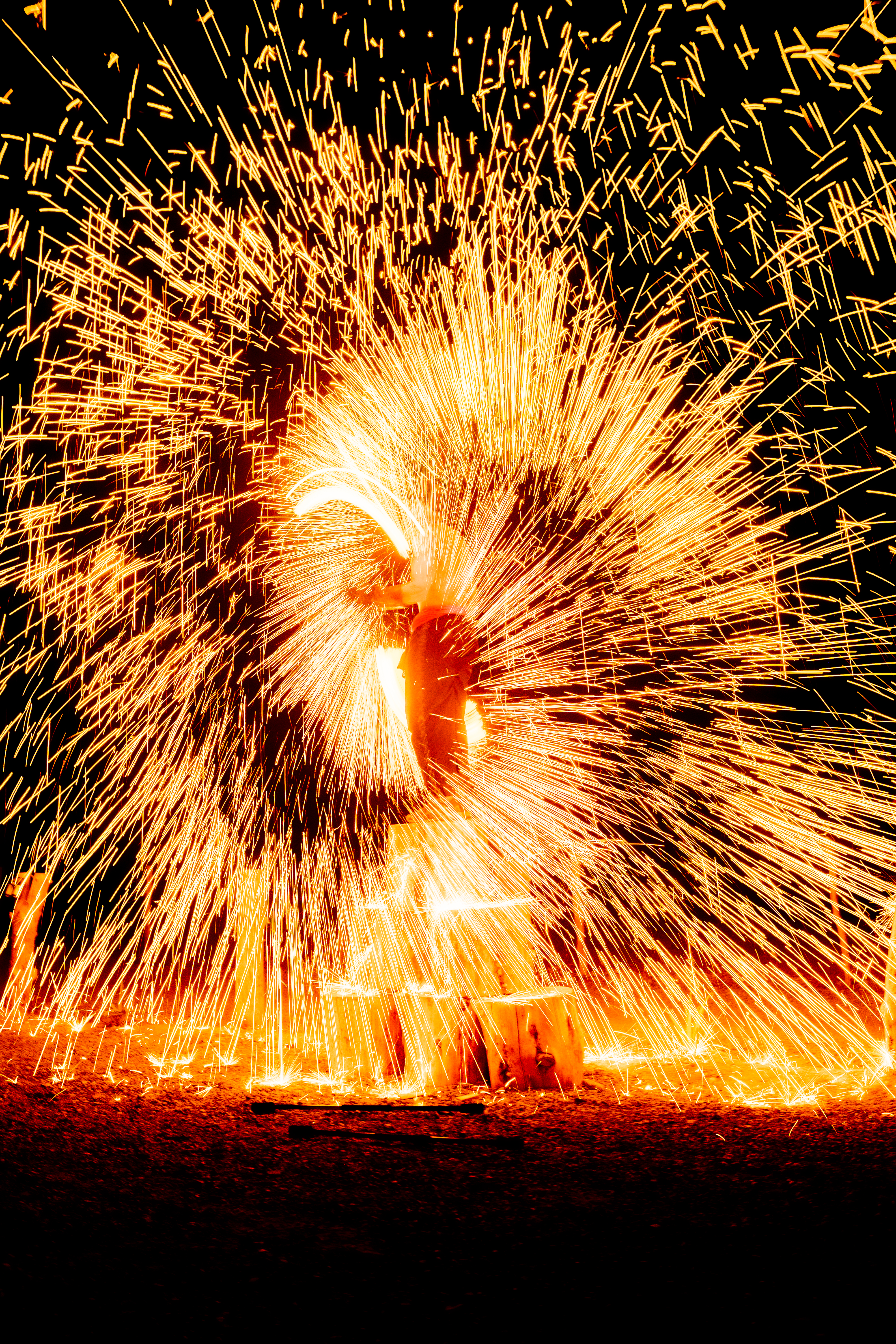 Steel wool fire spinning with sparks flying at night